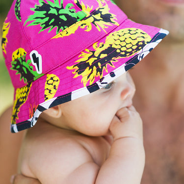 Lifestyle photo of baby in floppy sunhat Little Hotdog Watson pionner in print pineapple punch (Image #6)